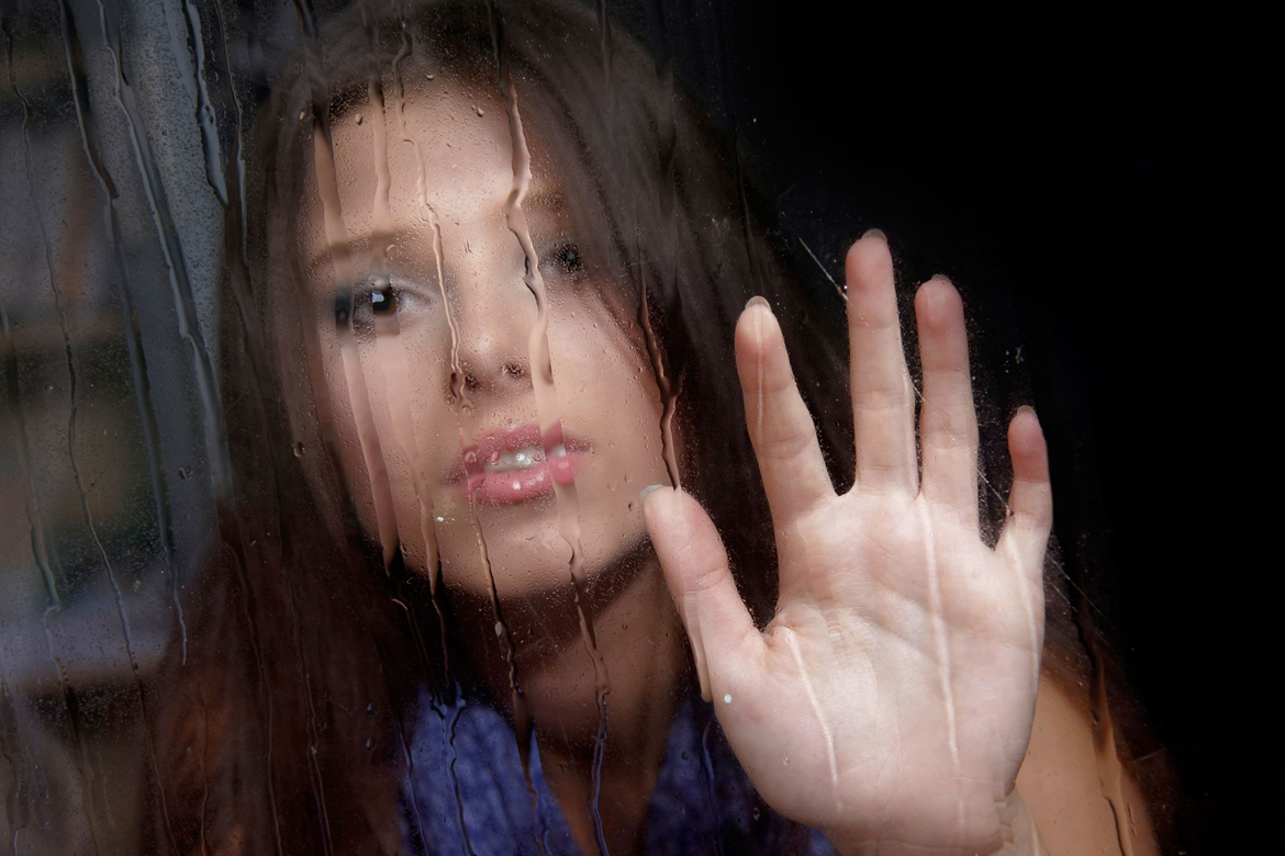 Sad and wet. Rain Raspberries girl behind Glass